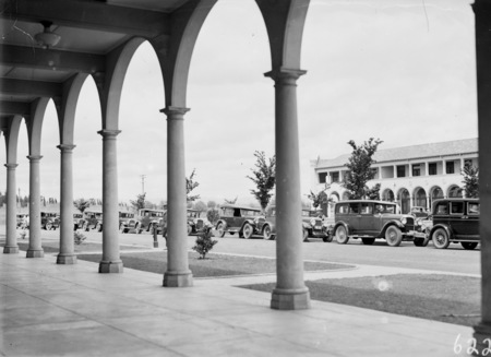 Cars lined up on Northbourne Avenue, from the Colonnades of the Sydney Building. Melbourne Building across the street.