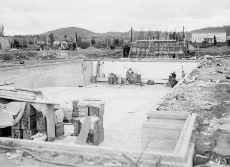 Manuka swimming pool under construction. Wall tiles being installed. Manuka Circle, Kingston.