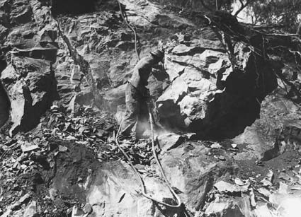 Quarry man using jack hammer