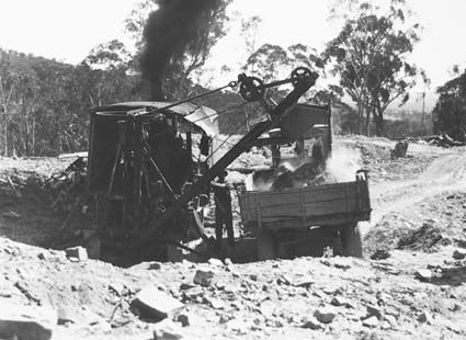 Steam shovel loading a motor truck