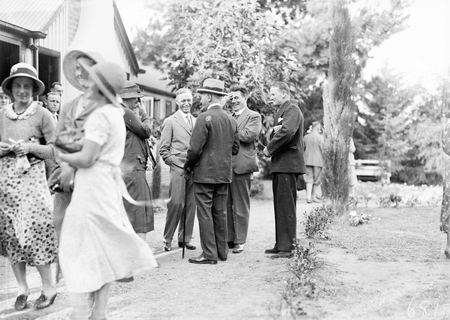 Group of people talking at the opening of new Golf Club House. Includes Canon Edwards, Headmaster of Canberra Grammar School, and Captain Bracegirdle.