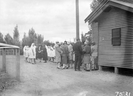 Group of men and women with junior Red Cross girls from the Hospital Auxilliary.