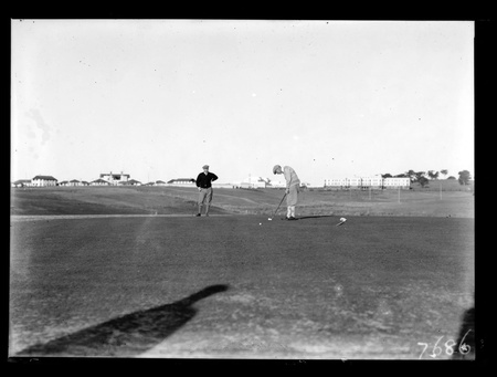 Golf championship finals - two golfers putting on the final green.