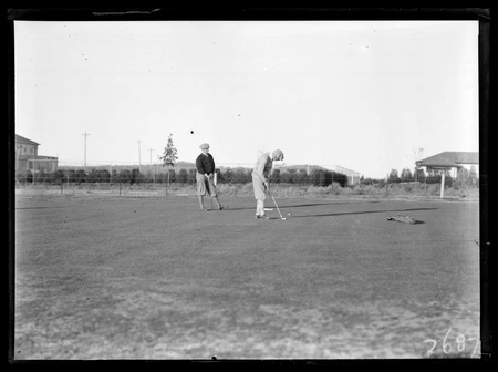 Golf championship finals - two golfers putting on the final green.